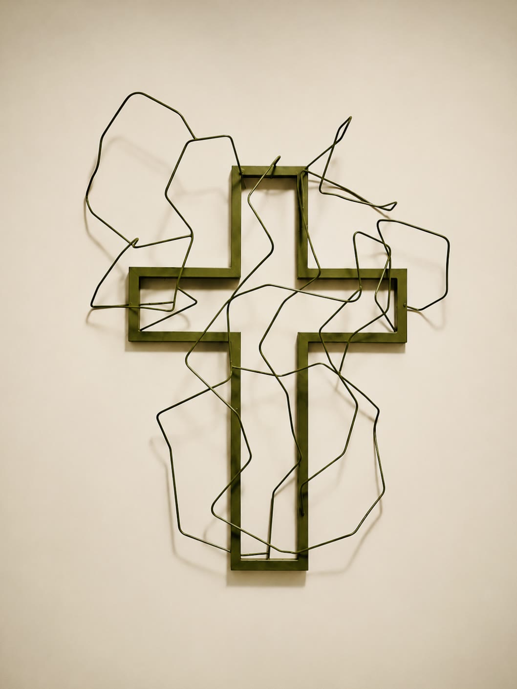 «Corazones crucificados»: cruz de acero verde rodeada de alambre continuo